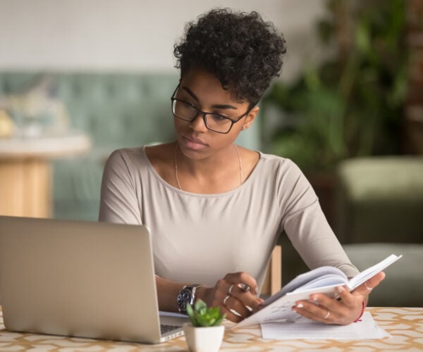 Teacher studying laptop and resources